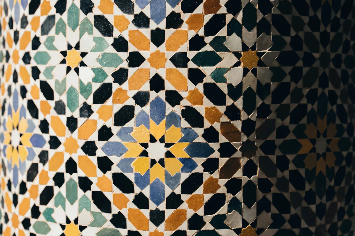 Detalle de mosaicos geométricos en tonos verdes, azules y ocres